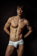 Strong Stripped Muscle Male Model In White Underwear On Black Isolated Font Background