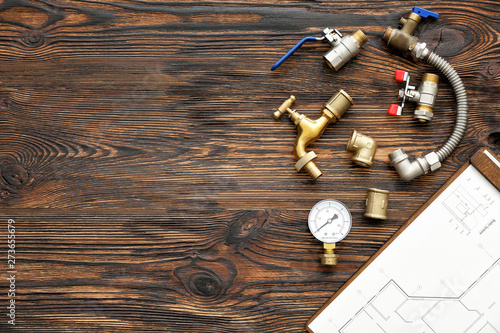 Fotomural Set of plumbing items with house plan on wooden background