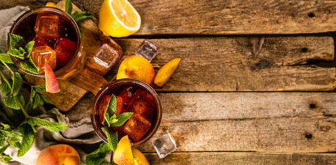 Wall Mural - Iced tea and ingredients in glasses on wood background, copy space