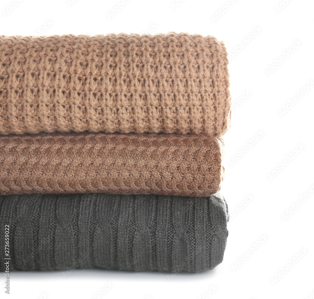 Stack of warm clothes on white background
