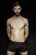 © Oleh Phoenix - Muscle strong bearded face beautiful stripped male model in black underwear on black isolated font background