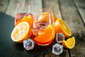 Aperol and ingredients drinks on wood background, copy space