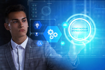 The concept of business, technology, the Internet and the network. A young entrepreneur working on a virtual screen of the future and sees the inscription: Continuous improvement