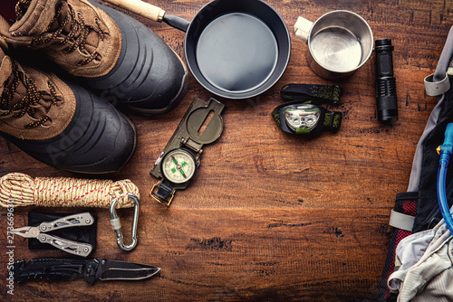Cuadros en Lienzo Outdoor travel equipment planning for a mountain trekking camping trip on wooden background