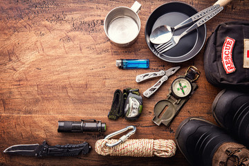 Wall Mural - outdoor travel equipment planning for a mountain trekking camping trip on wooden background. top vie