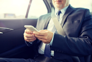 Canvas Print - transport, business trip, technology and people concept - senior businessman texting on smartphone and driving on car back seat