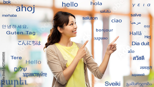 translation, education and people concept - happy asian young woman pointing fin Fototapete