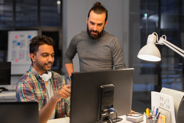 deadline, technology and people concept - creative team s with computers working together late at night office