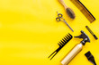 professional accessories of hairdresser with combs and sciccors on work desk yellow background top view copyspace