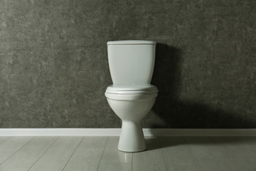 Poster - New toilet bowl near grey wall indoors