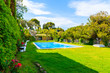 TOSSA DE MAR, SPAIN - JUN 3, 2019: Swimming pool in garden of luxury house in Tossa de Mar town, Costa Brava, Spain.