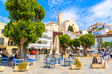 Poster - CADAQUES VILLAGE, SPAIN - JUN 4, 2019: Church square with restaurants in Cadaques port, Costa Brava, Spain.