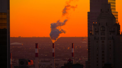 CLOSE UP: Thick smoke rolls out of industrial chimney at golden autumn sunset.