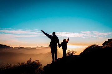 happy father and daughter travel in mountains at sunset