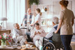 © Photographee.eu - Young nurse taking handicapped senior man on the wheelchair to his friends