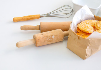 Several equipment or tools for bakery cooking including rolling pin, whisk and bowl or cup, all are put on white table