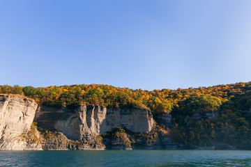 river and rocks on the shore covered with autumn forest. view fr