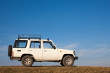 White jeep parked on a high hill off-road.