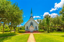 A Small White Methodist Church Down A Brick Walk Under Blue Skies