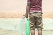 © Golib Tolibov - Plastic pollution on land. Little boy collecting plastic bottles. Kid carry garbage bag. Free space