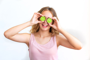 Pretty charming joyful attractive cheerful funny comic positive girl having two pieces of lime, closing two eyes, isolated on white background with copy space for advertisement