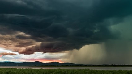 dramatic thunderstorm with lightning over the lake during sunset, timelapse video. beautiful fiery c