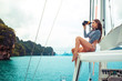 © Detkov D - Luxury female posing with binoculars in hands. Model wearing fashion striped bikini while yachting. Beautiful nature background
