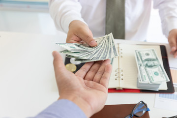 Business and finance concept, Hand of a businessman giving money to his partner.