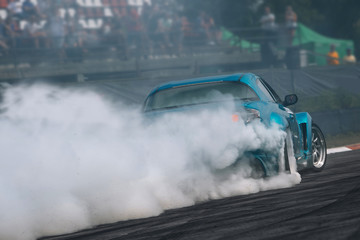 Canvas Print - Sport car in motion with a lot of smoke. Race car make a turn at high speed