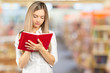 © fotofabrika - Portrait of a happy student girl or woman with books in library