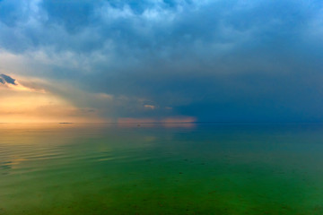 Sea, green water and horizon with clouds