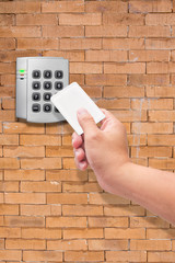 Wall Mural - hand use key card for Security entrance pad on  brick wall