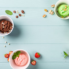 Flat lay, overhead shoot of homemade assorted ice cream on light blue wooden background. Healthy summer food concept. Top view, copy space.