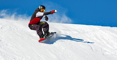 Fototapete - Snowboarder in azione su pista con neve fresca 