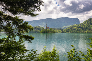 beautiful view on famous bled lake with church on island in stormy sky in julian alps, slovenia