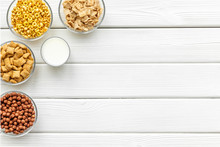 Various Corn Cereals In Bowls And Milk On White Wooden Background Top View Copyspace