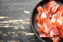 Frying Pan With Cooked Bacon On Dark Table