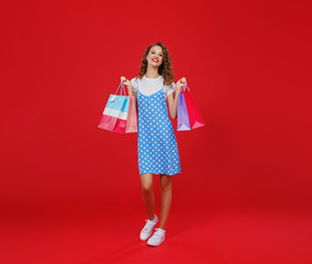 Wall Mural - concept of shopping purchases and sales of happy   girl with packages  on red background.