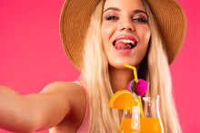 Blonde Girl In A Bathing Suit And Hat Holding A Cocktail In Her Hands