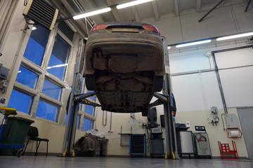 Modern car raised on a lift for repair.