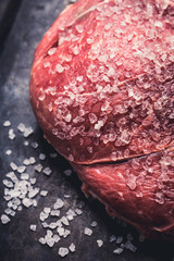 Wall Mural - Raw fresh meat with salt on the rustic background. Selective focus. Shallow depth of field. 