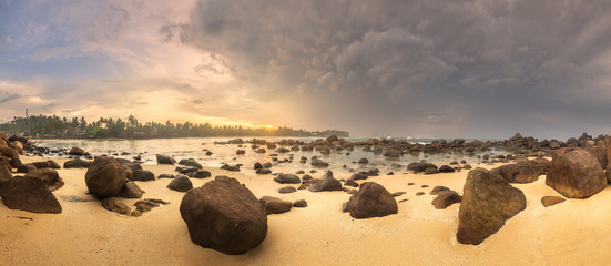 Wall Mural - tropical beach with rocks on sand coast of ocean