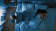 © Gorodenkoff - Depressed and Stressed Young Man Sits on the Edge of Bed at Night, Suffering From Insomnia Because of Sex Problems. His Young Wife Lies Beside Him Feeling Empathy.