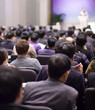 © Right 3 - Speaker giving speech at business seminar in auditorium. Background of presenter in hall meeting during public lecture. Defocused businessman in conference hall with bokeh.
