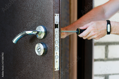 Handyman Repair The Door Lock In Metal Entrance Door Man