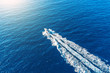Boat launch at high speed floats to sunlight in the Mediterranean, aerial top view.