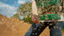 CLOSE UP: Woman Spinning A Handle And Sowing Grass Seeds Across Fertile Land.