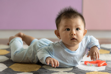 Cute baby boy is lying on the floor, Looking at wonder to family concept.