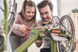 © Westend61 - Young man and little girl repairing bicycle together