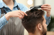 © New Africa - Barber making stylish haircut with professional scissors in beauty salon, closeup
